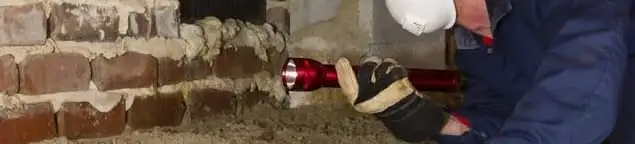 Pest control technician inspecting a crawl space for ant activity and entry points in Lincoln, NE